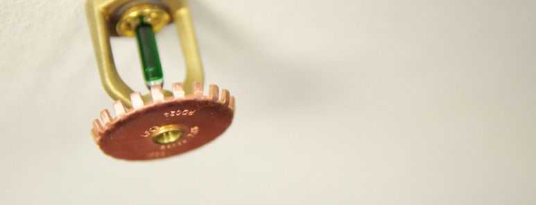 A photo of a sprinkler on a ceiling