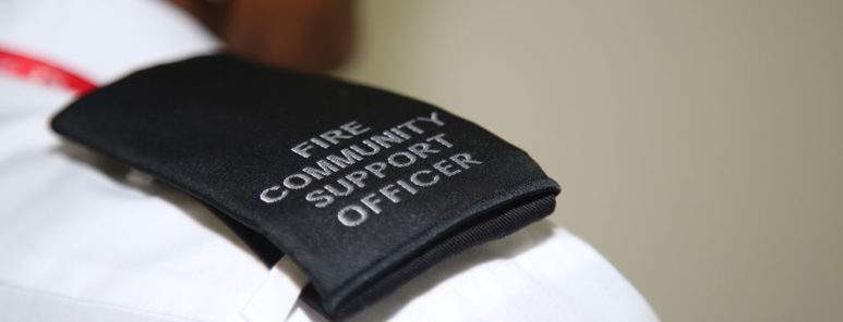 A uniform lapel reading Fire Community Support Officer